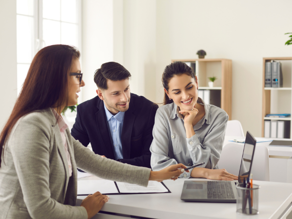 Three professionals reviewing ATO online authorisation steps together on a laptop in a modern office, representing secure client-to-agent linking for registered BAS agents.